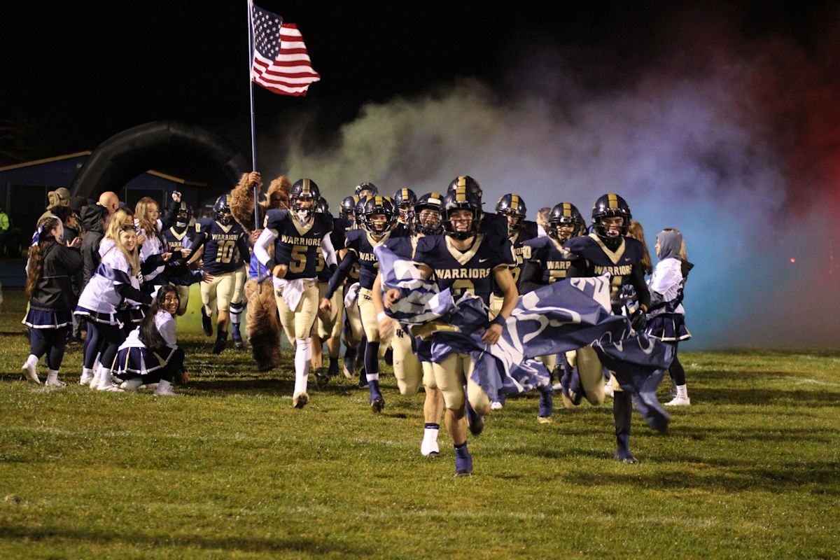 Del Norte High Warriors football players taking the field